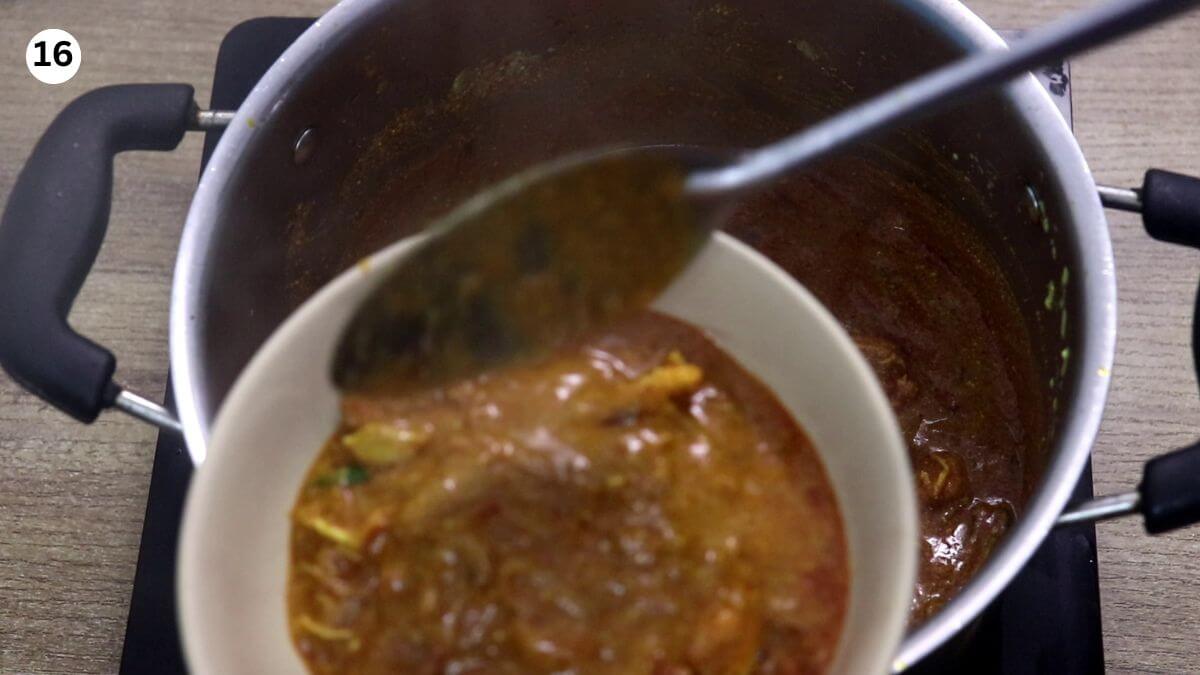 removing half of the cooked prawn masala to layer biryani.