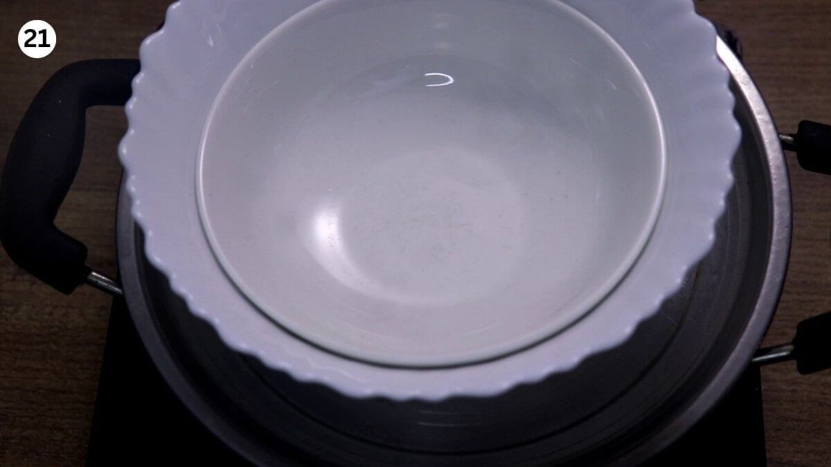 showing sealing the biryani pot's lid with weight to cook prawn biryani on dum.