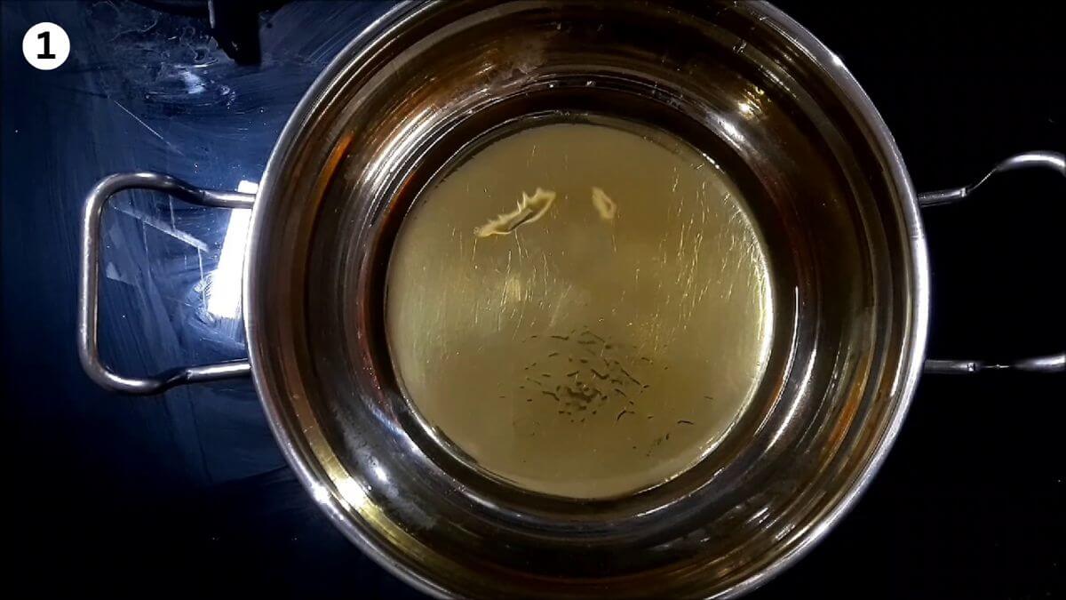 heat ghee in a pan to make besan burfi recipe.