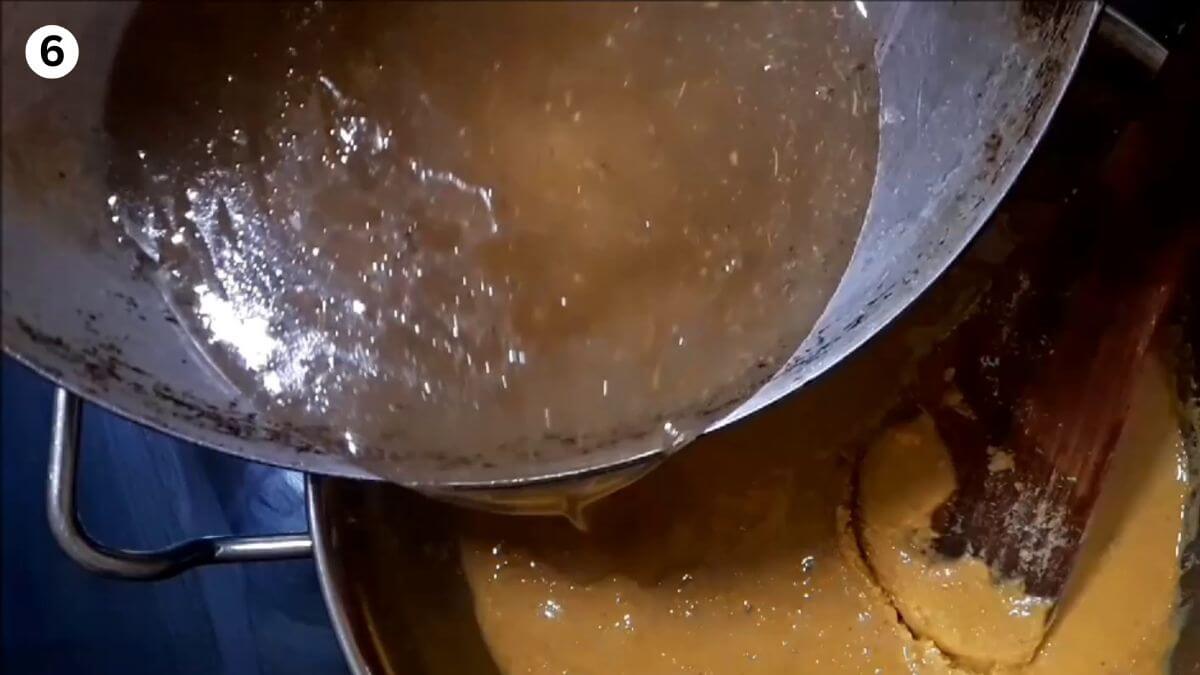 addition of sugar syrup to roasted besan to make burfi recipe.