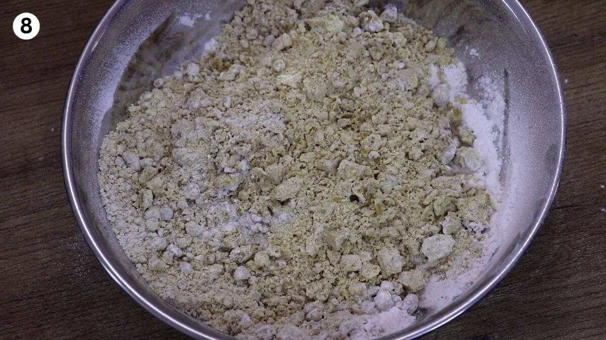 addition of boora and cardamom powder to roasted besan to make ladoo.