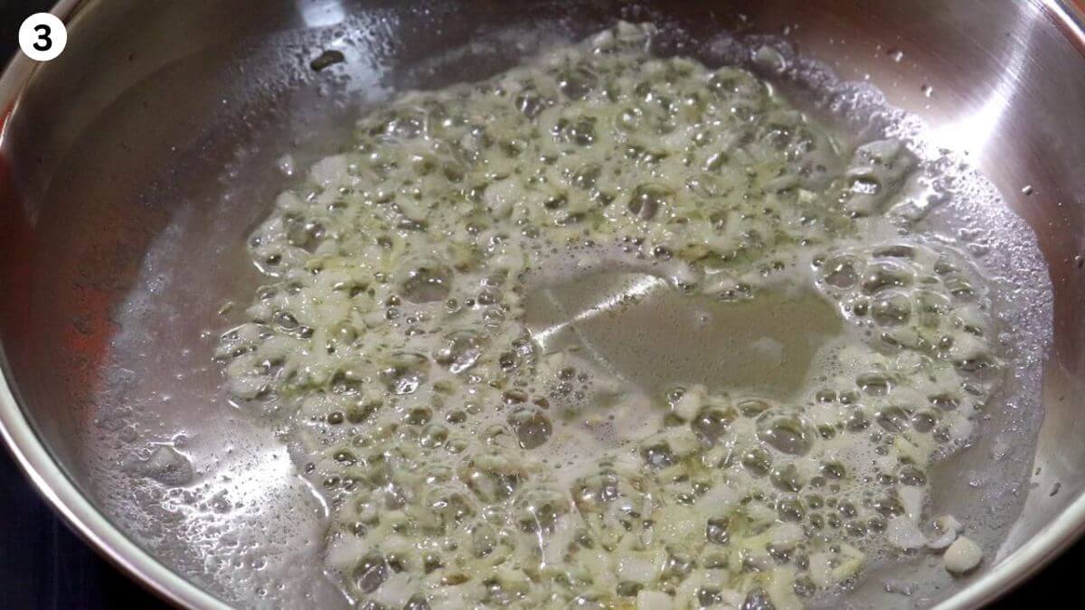 frying garlic in butter to make garlic chicken curry.
