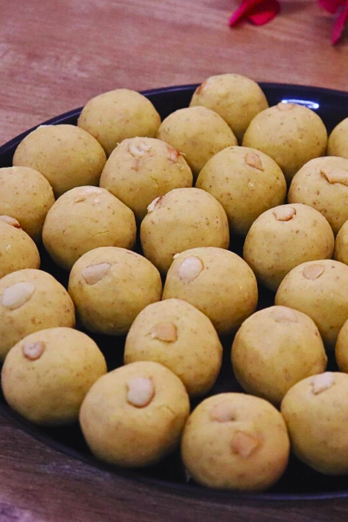 danedar besan ladoo served in a black colored plate.