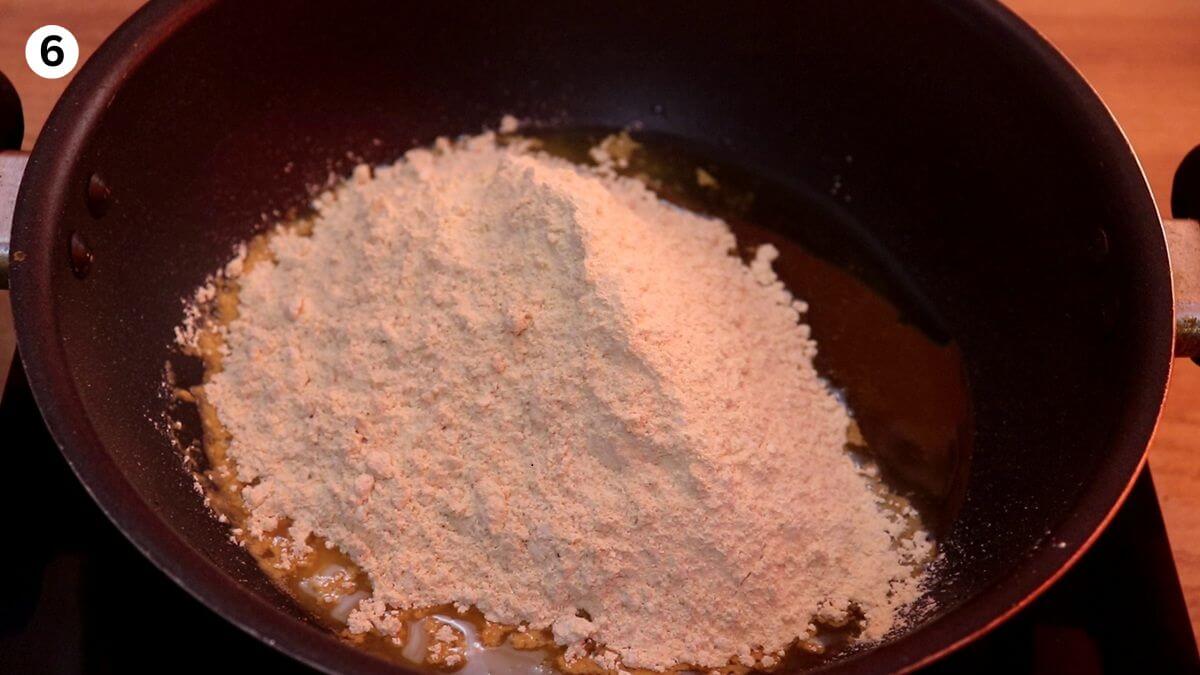 roasting powdered moong dal with ghee in a kadhai until golden.