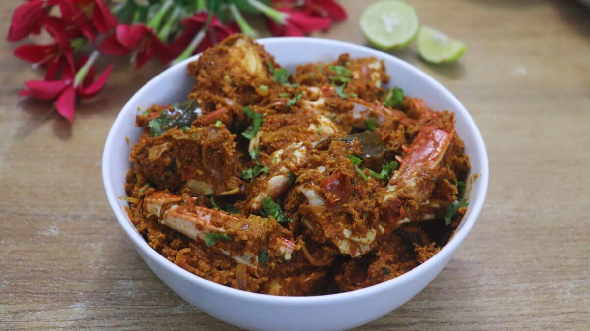 crab sukka served in a white bowl with lemon wedges served on the side.
