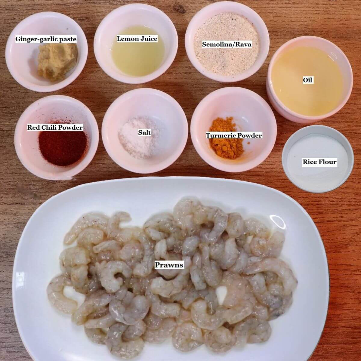 individually labelled ingredients to make goan prawn fry recipe are laid out on a table.