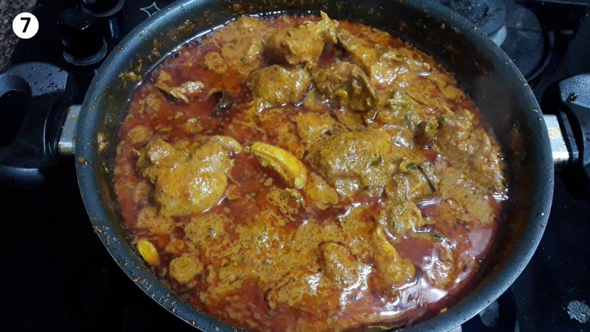 cooked hyderabadi chicken masala curry in a black pan.