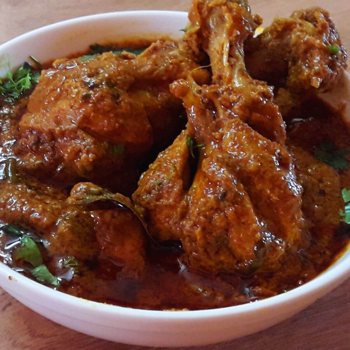 hyderabadi chicken masala served in a white color bowl.