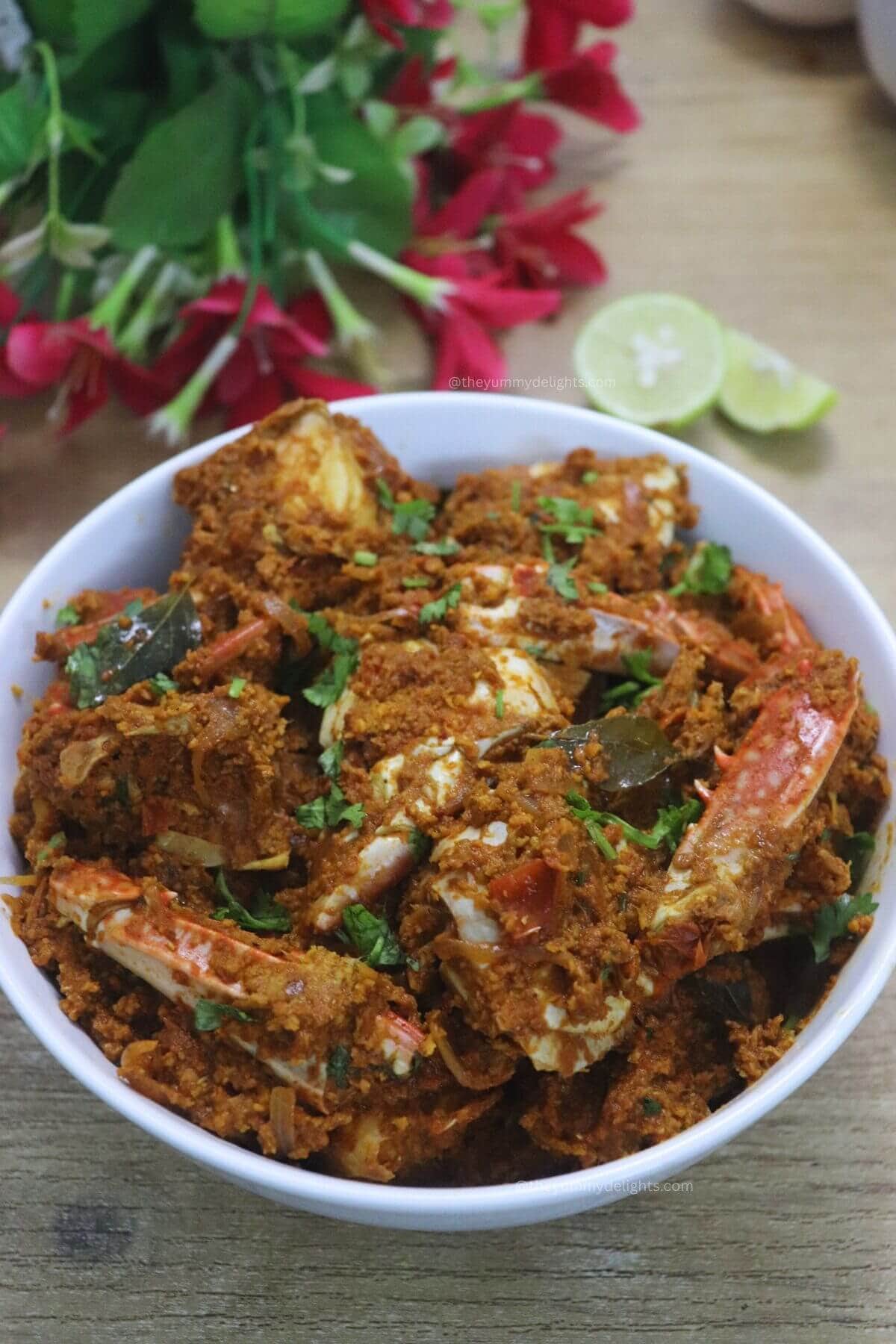 easy mangalorean crab sukka masala served in a white bowl, garnished with coriander leaves.
