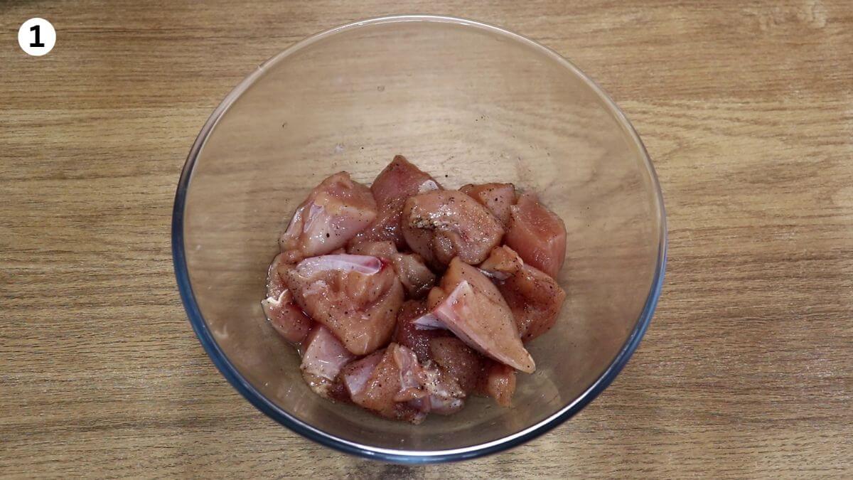 seasoning the chicken with salt and pepper to make Mediterranean stew.