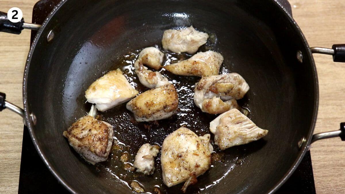 sauteing chicken in the pot to make chicken stew.