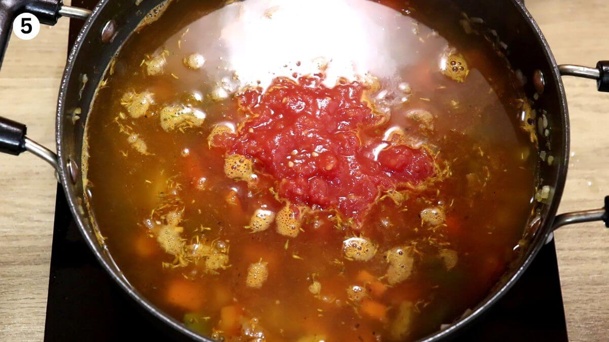 addition of chicken broth and tomatoes to make Mediterranean chicken stew.