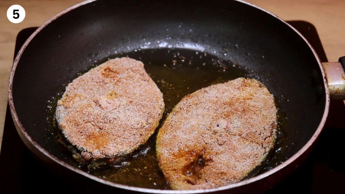 Adding the rava-coated fish to the pan for frying.