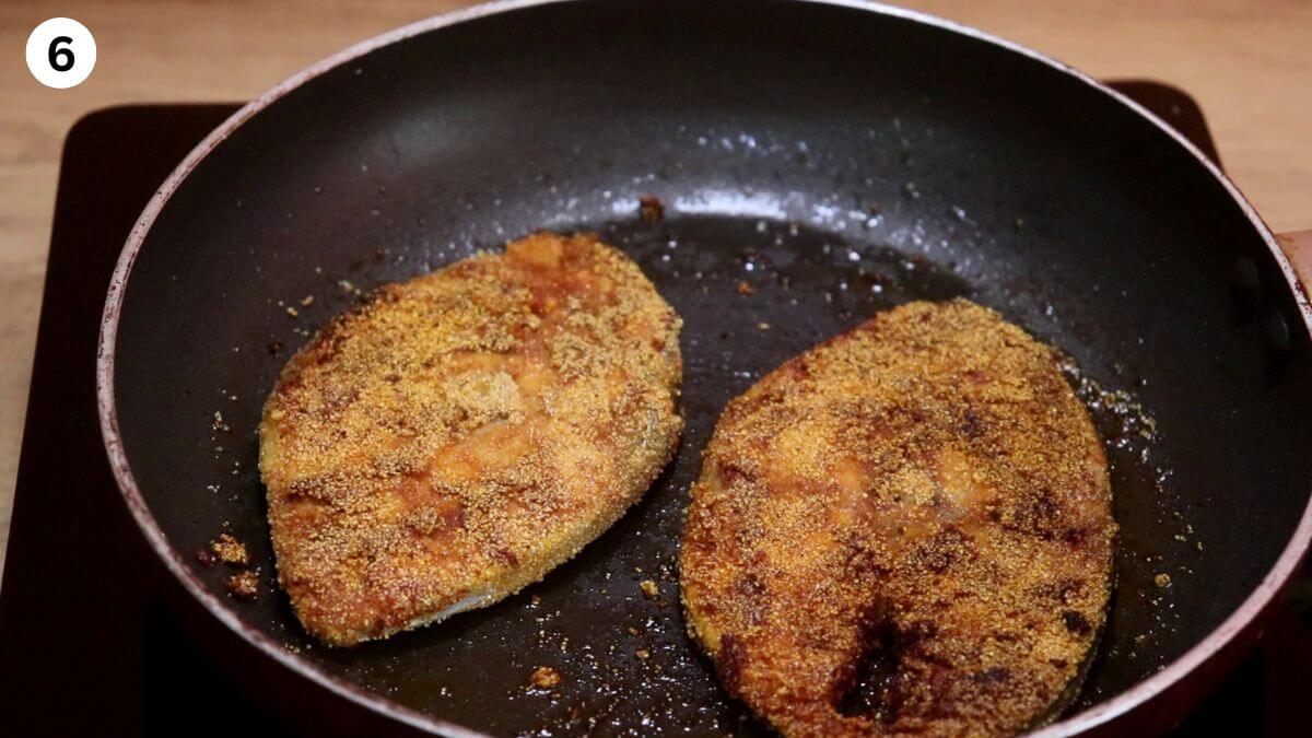 rava fish fry in a black color pan.