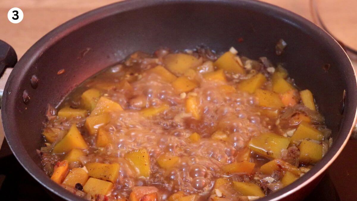 addition of spices and water and cooking roasted pumpkin to make soup.