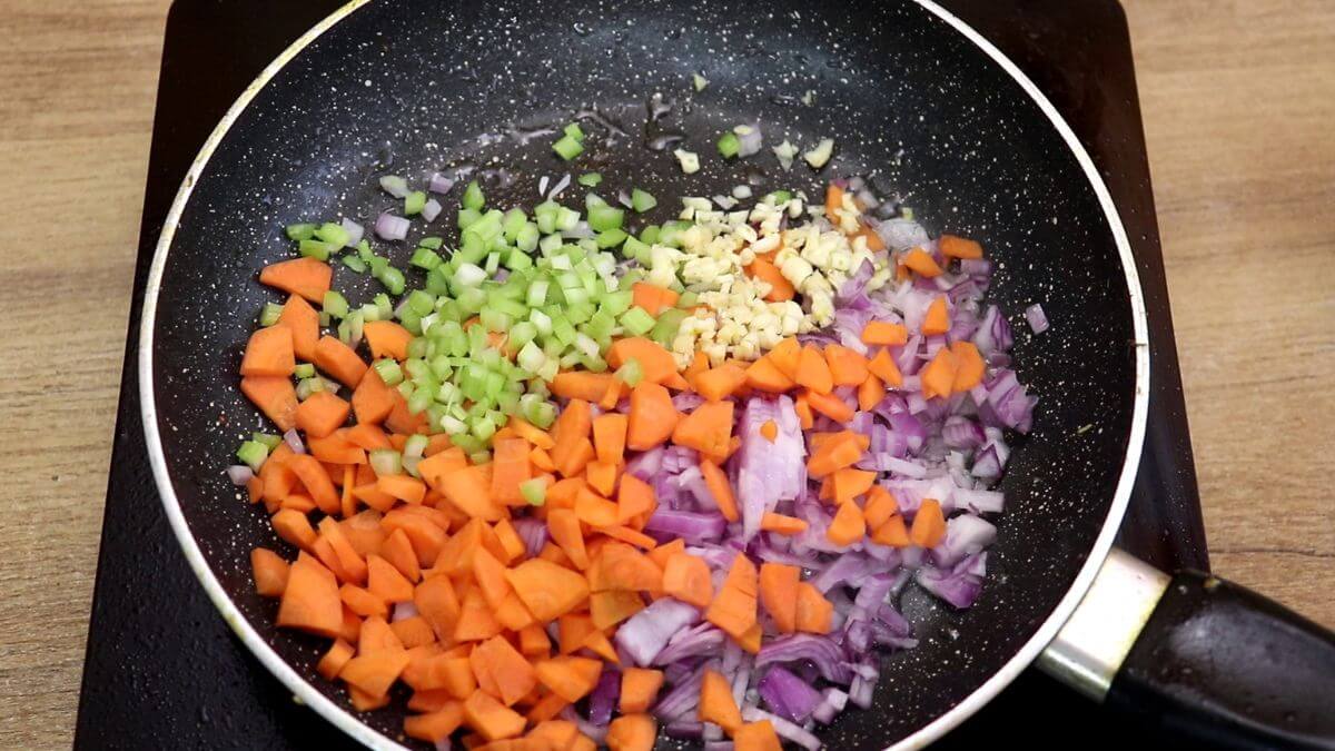 addition of vegetables to pan for making creamy chicken stew recipe.