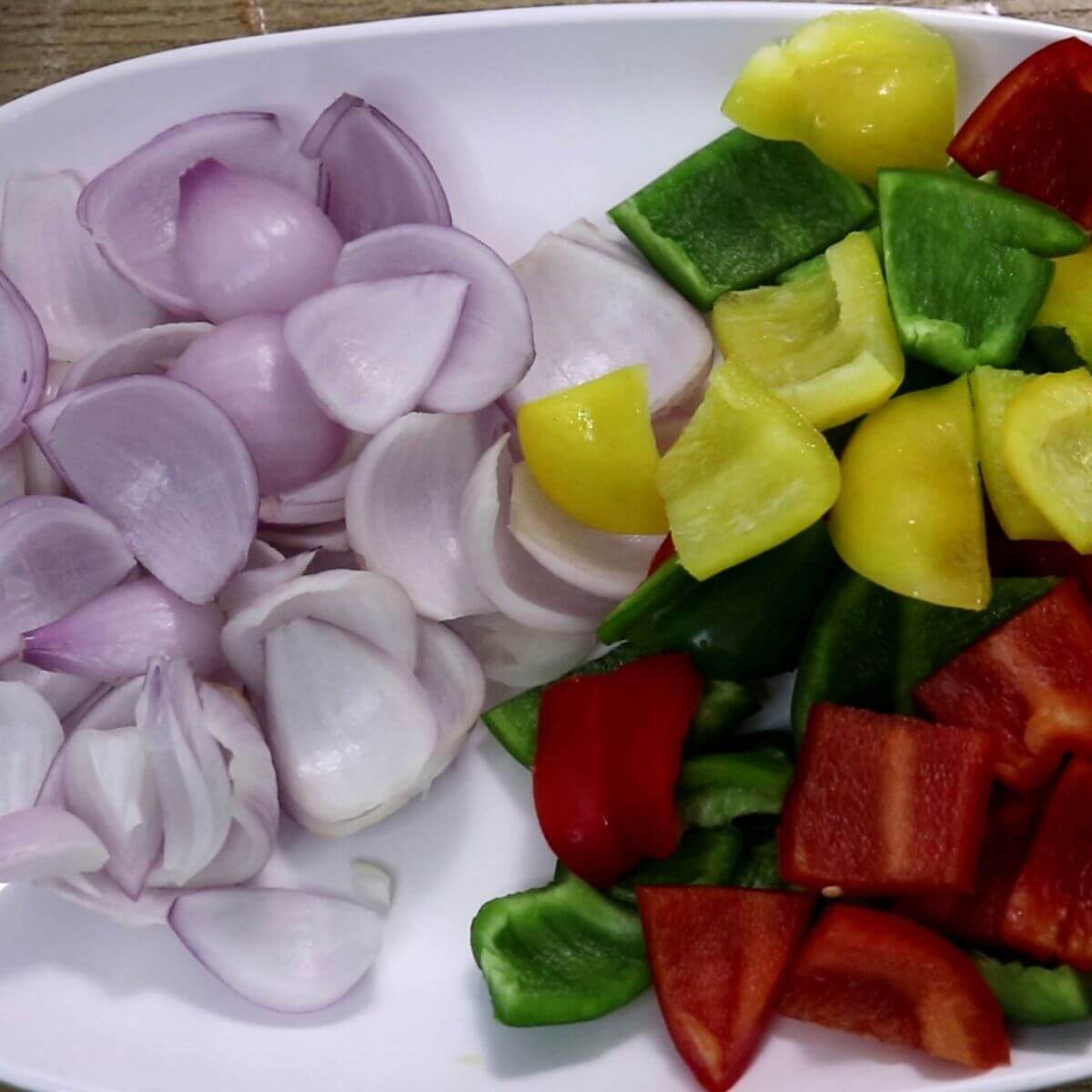 cubed onions and bell peppers on a plate.