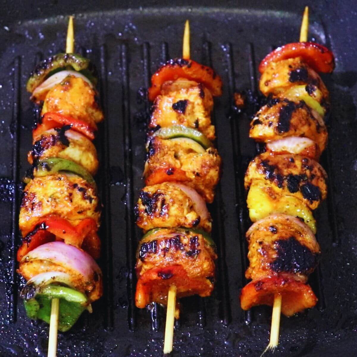 Harissa chicken skewers cooked on a grill pan.