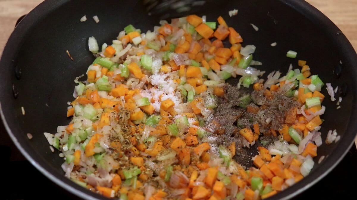 addition of spices and italian seasoning to make italian minestrone soup recipe.
