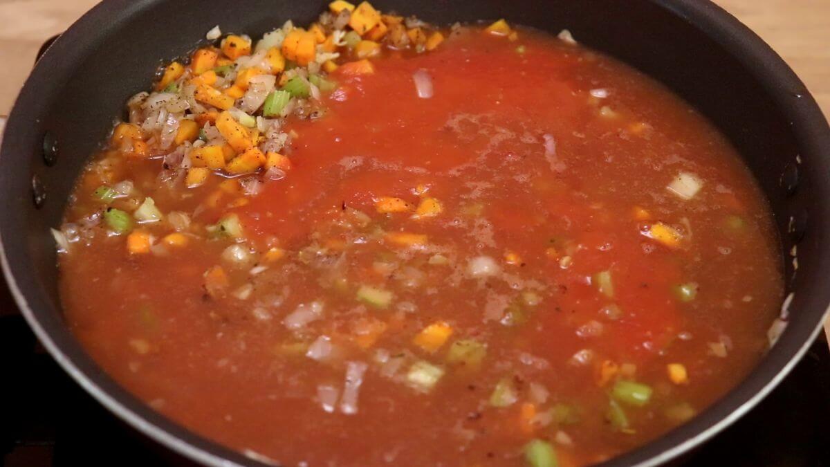 addition of crushed tomatoes and broth to make minestrone soup.