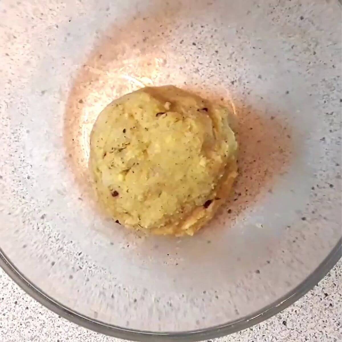 Potato nuggets ingredients mixed in a bowl with cheese, mashed potatoes, breadcrumbs, and herbs ready to shape.