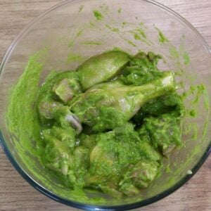 chicken marinated in green masala to make chicken xacuti curry.