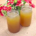 Homemade chicken stock filled in bottles and kept side by side.