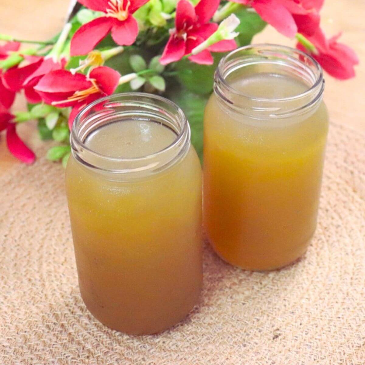 Homemade chicken stock filled in bottles and kept side by side.