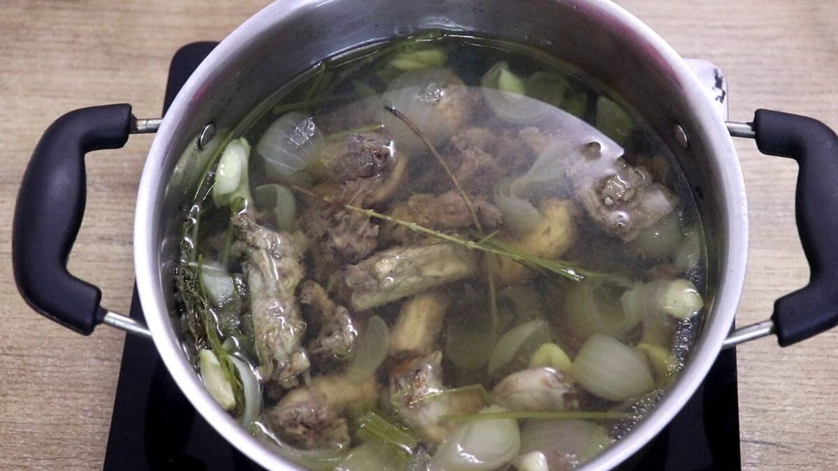 Chicken stock simmering slowly for two hours.