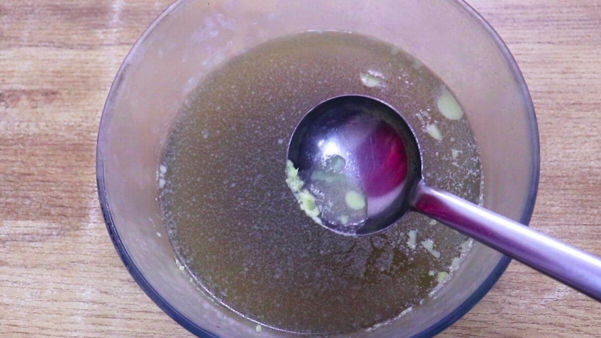 Fat layer being removed from cold homemade chicken stock.