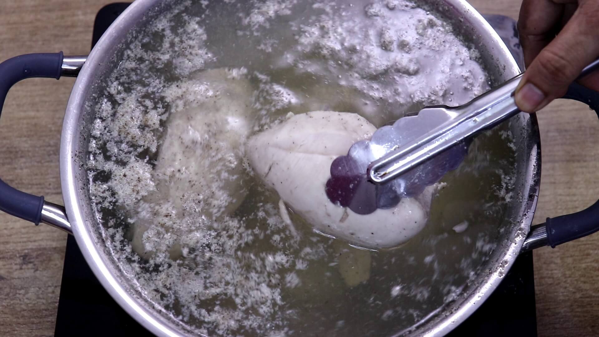 Cooked chicken breast removed from pot for shredding.