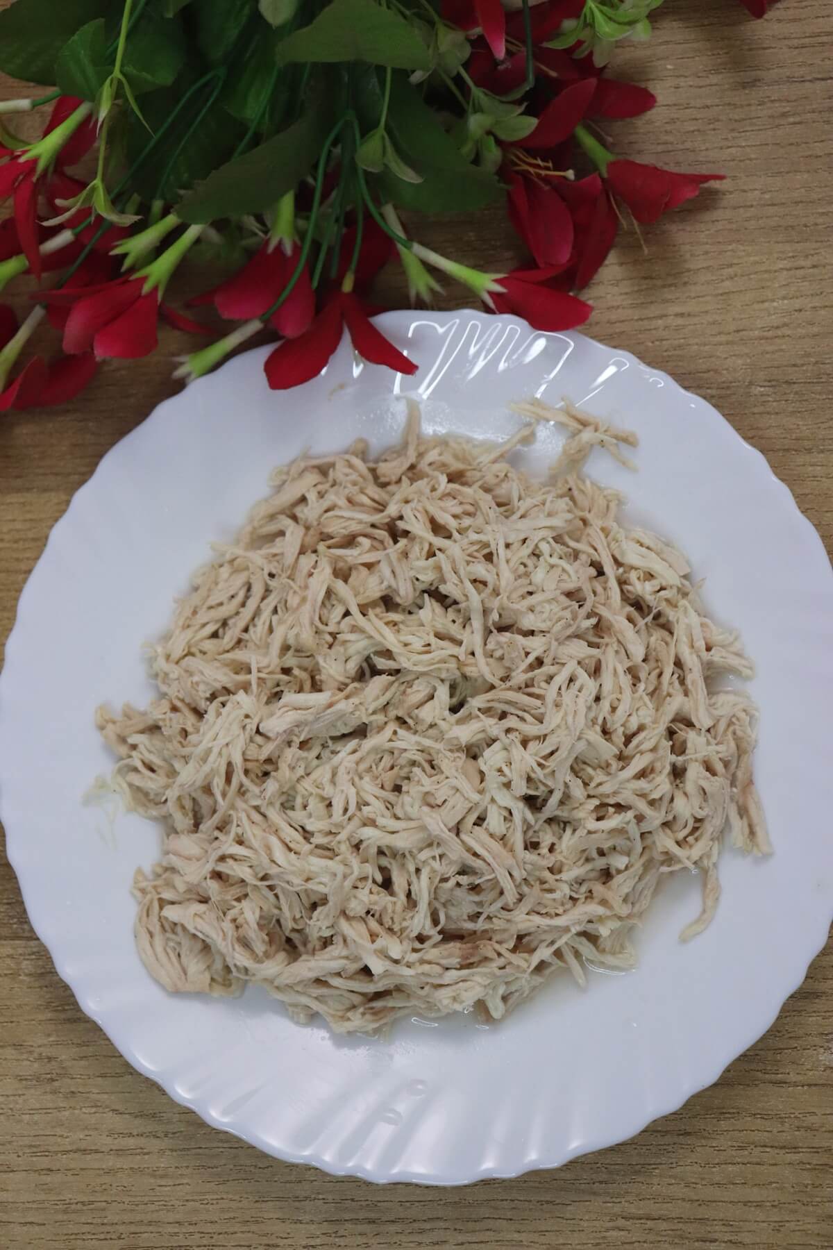 Shredded chicken placed on a plate ready for meal prep.