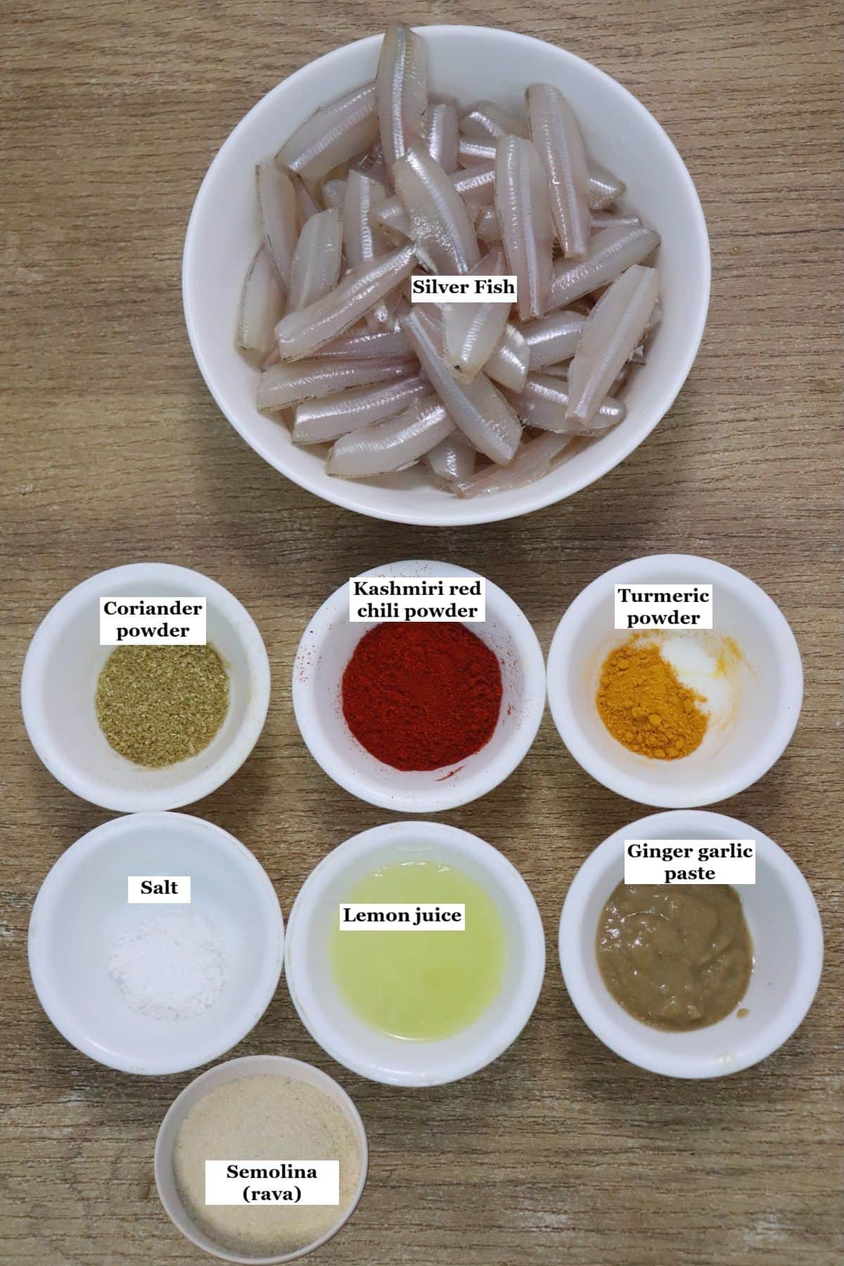 individually labelled ingredients to make silver fish fry recipe are laid out on a table.