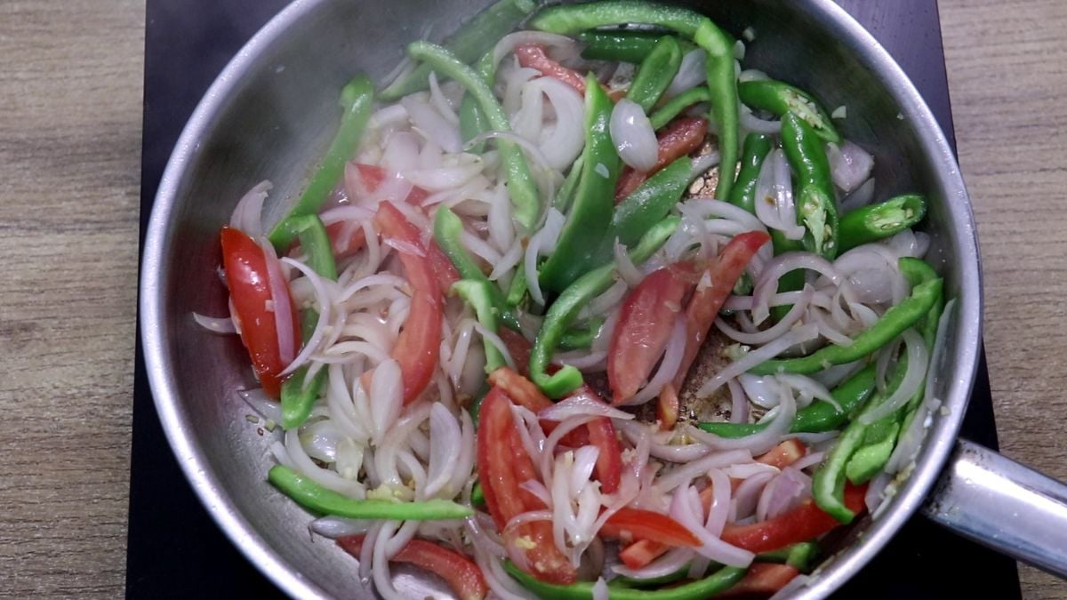 Tomato, green chilli, and capsicum added to pan.