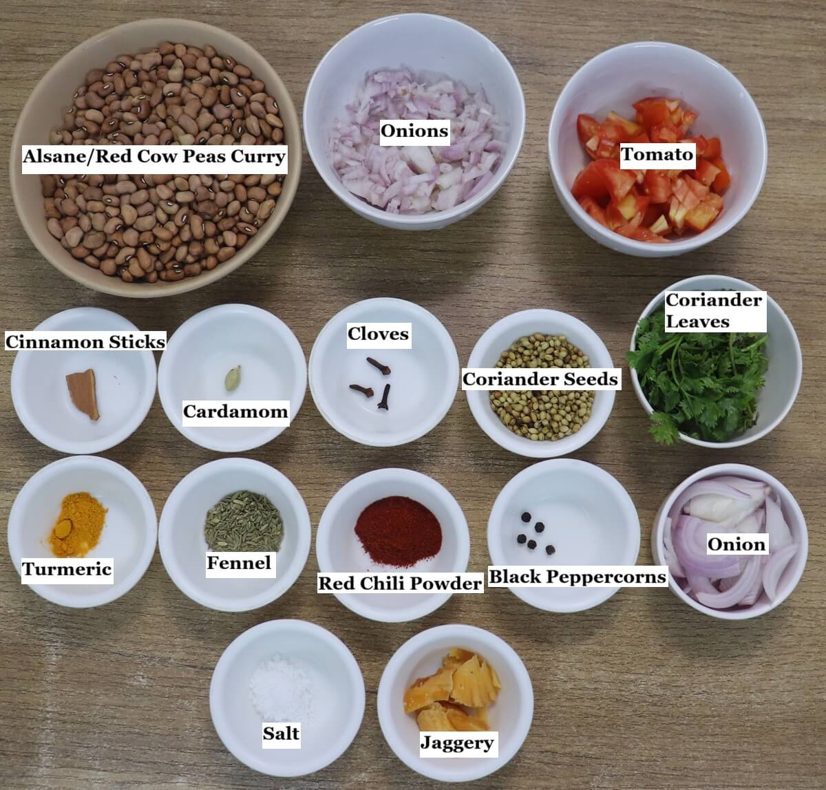 Individually labelled ingredients to make alsanyache tonak recipe are laid out on a table.