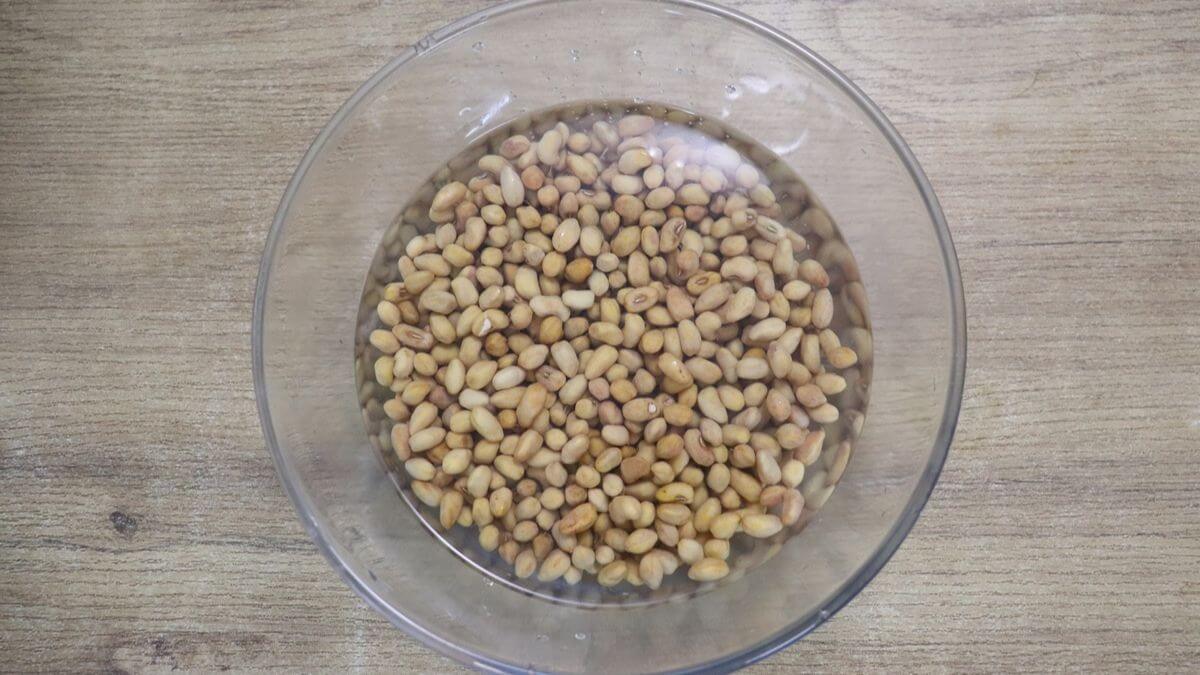 Soaking alsane (red cow peas) in water overnight.