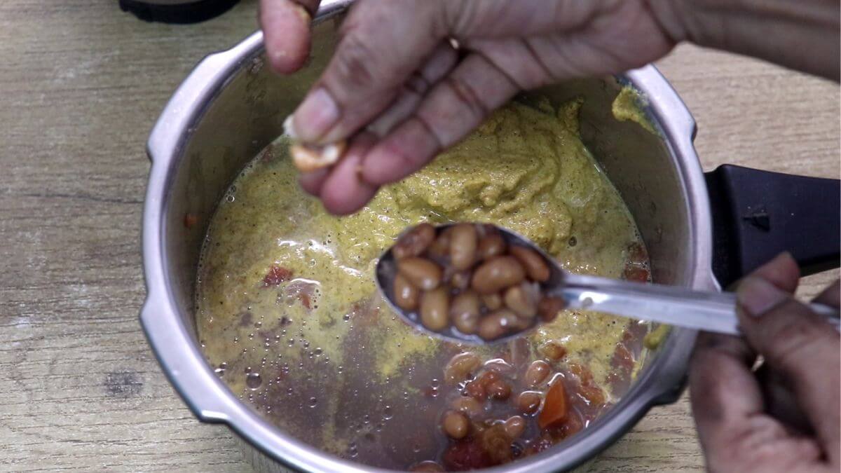 showing cooked alsane by pressing it between thumb and index finger.