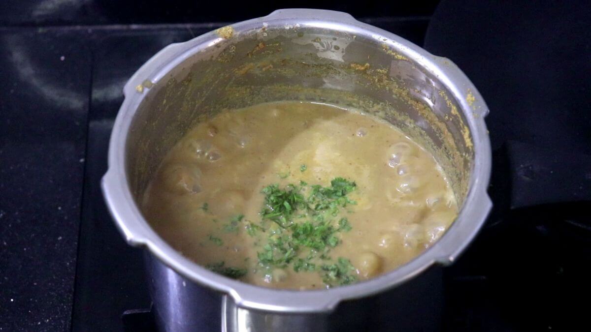 Simmering alsanyache tonak curry until thick.