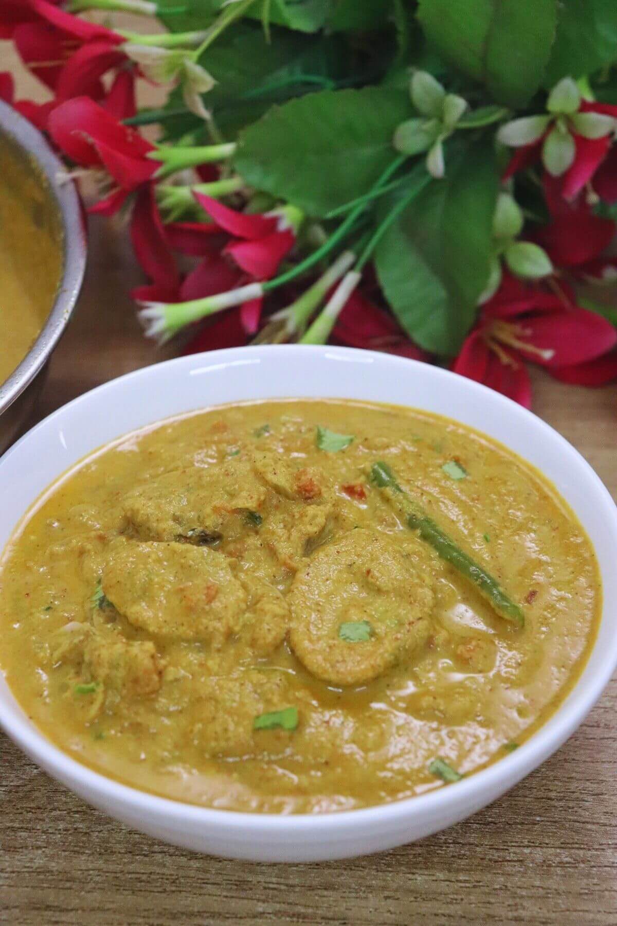 Goan clam curry (Tisryache Tonak) served in a bowl on a brown countertop.