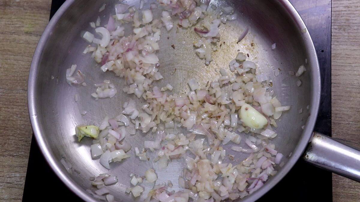 Sautéing chopped onion, ginger and garlic in oil.