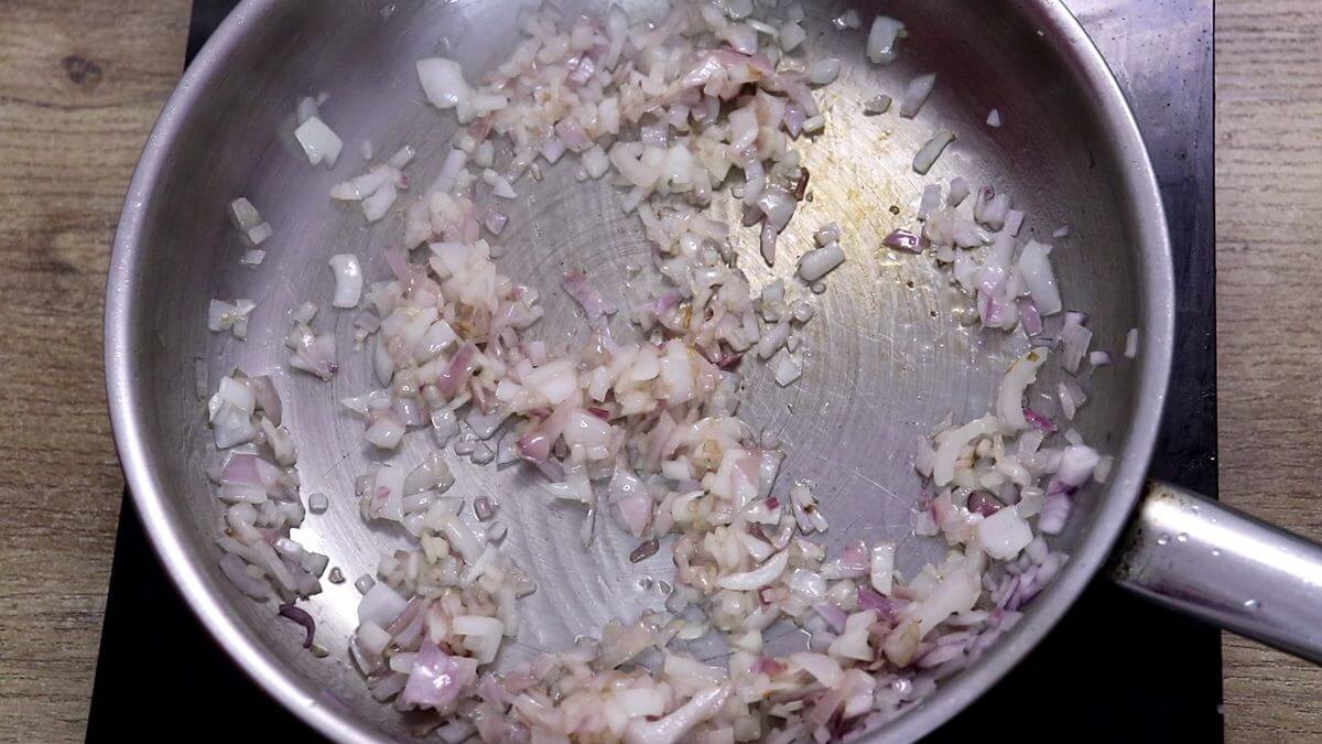 Sautéing chopped onion in a pan.