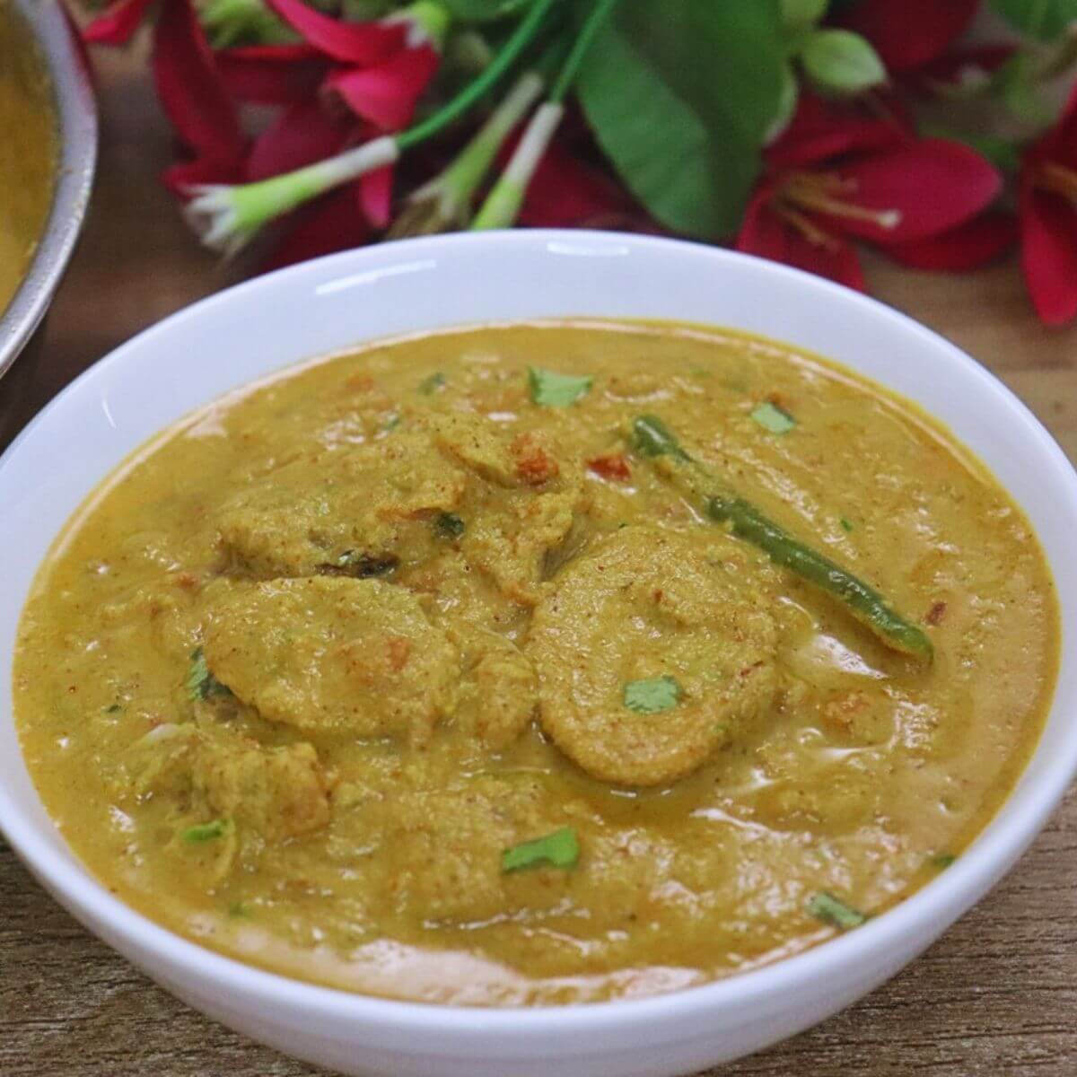 Authentic Goan Tisryache Tonak clam curry served in a white bowl.