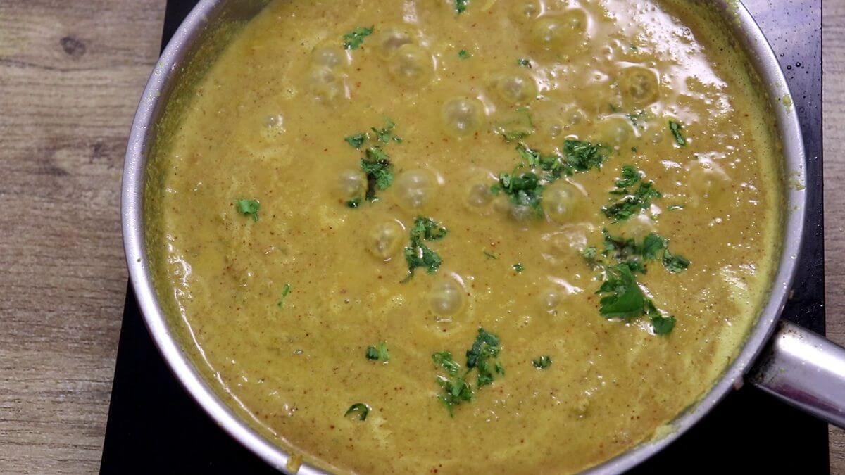 Finished Goan clam curry garnished with coriander.