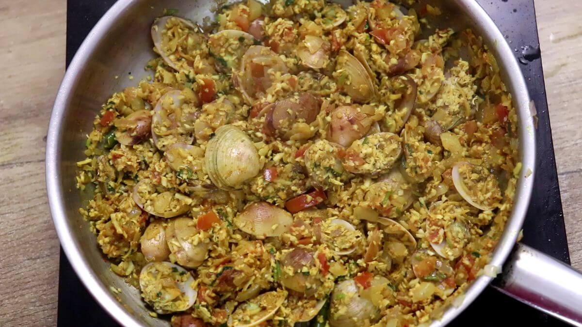Mixing coconut with clams to make tesri sukka.