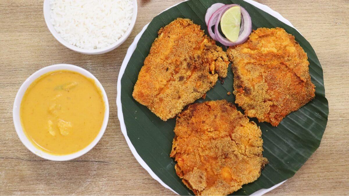 Crispy chonak rava fry served with a bowl of rice and curry on the side.