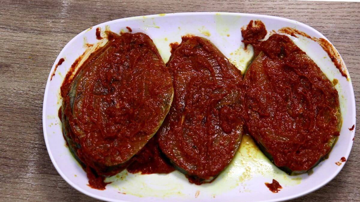 apply the homemade masala on the fish to make anjal fish fry.