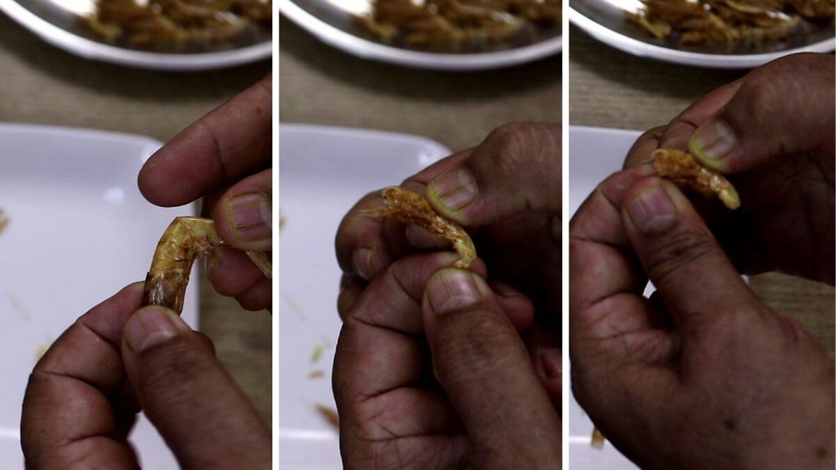 Removing head, tail, and legs from dry prawns.