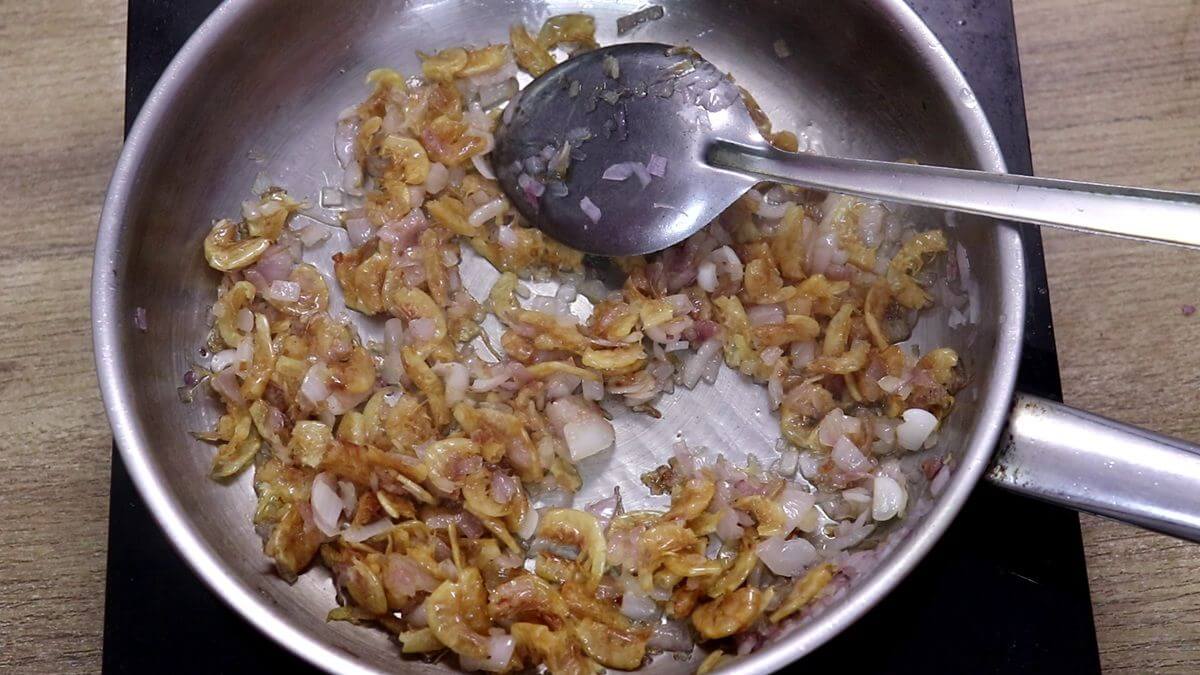 Addition of prawns and sauteing it with onions for kismoor recipe.