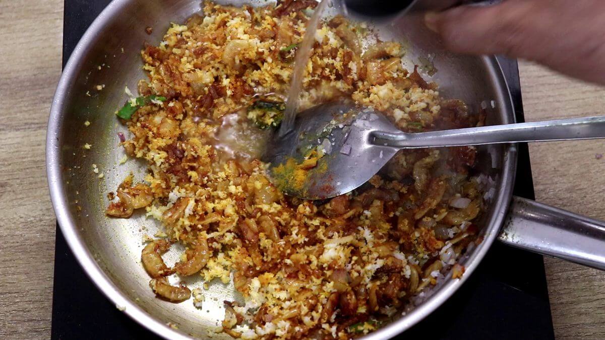 adding a splash of water to prawns kismoor.