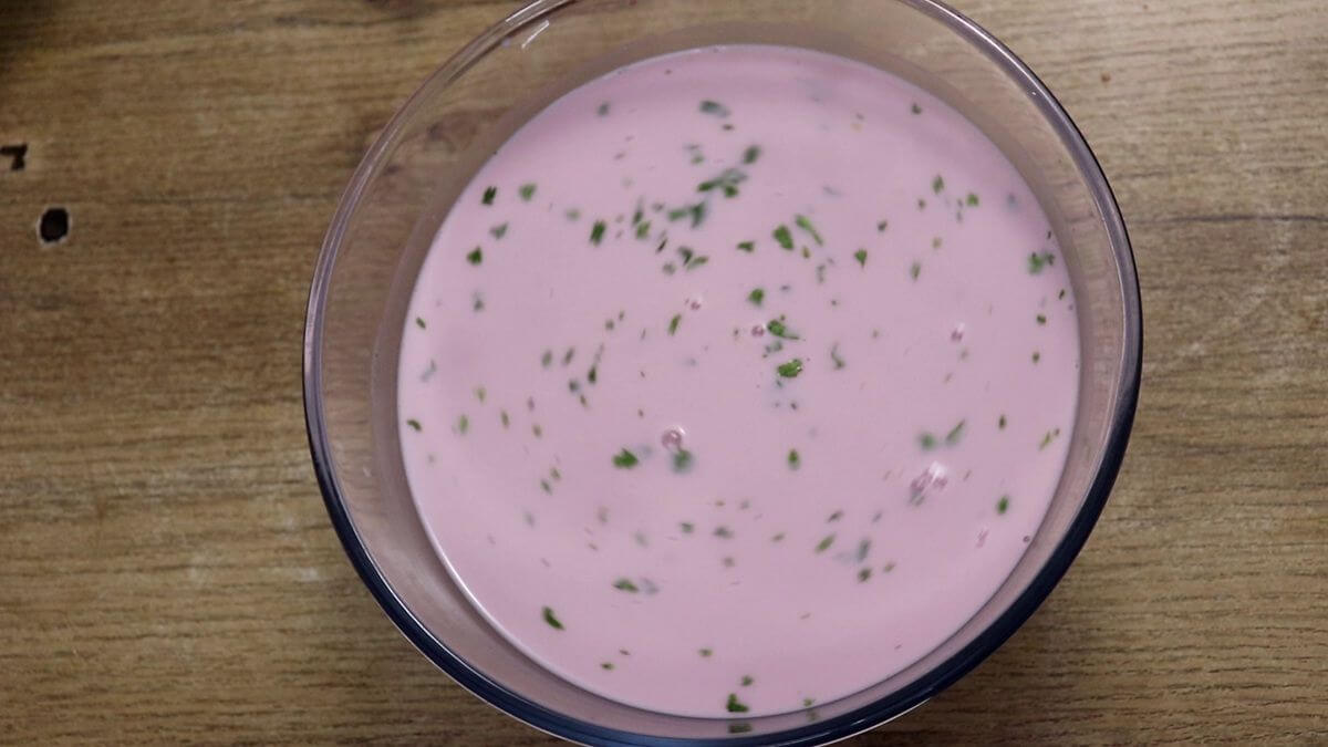 garnishing goan solkadhi with coriander leaves.
